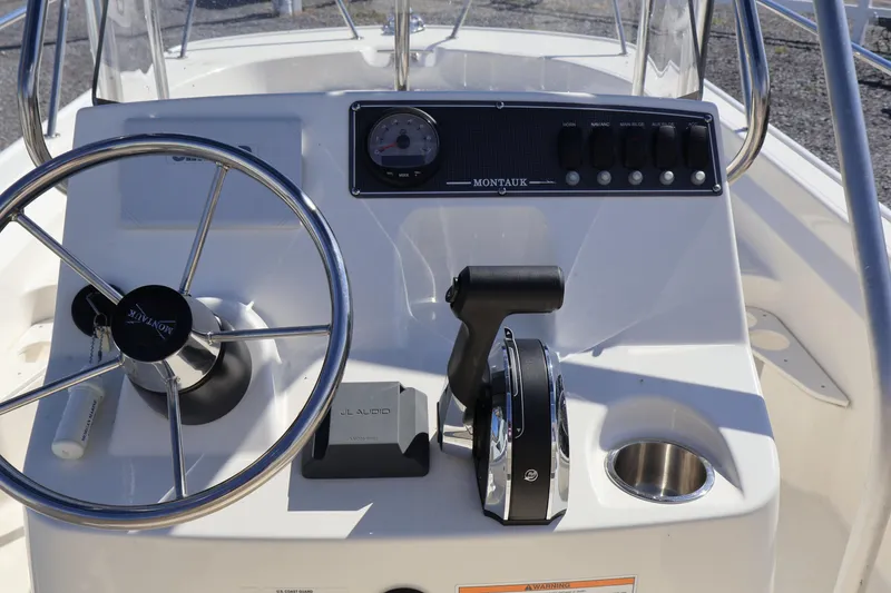 Slide: The Image of 2023 Boston Whaler 170 Montauk boat console with steering wheel and controls. - 25