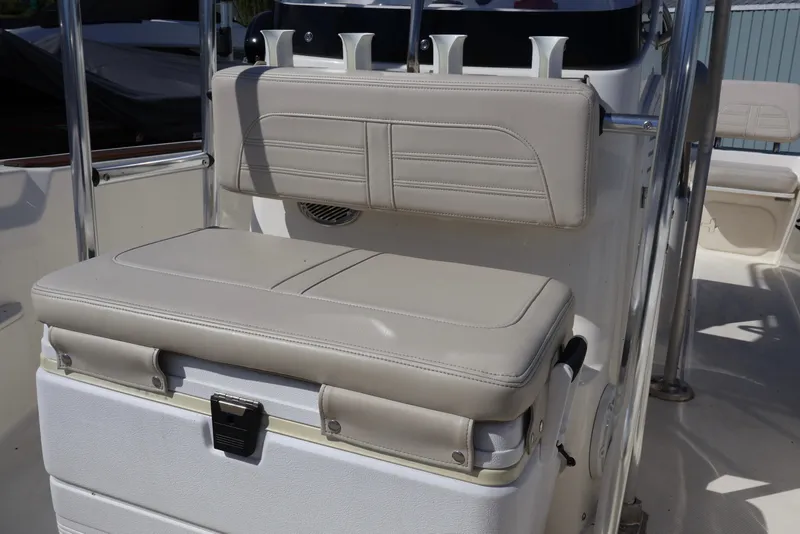 Slide: The Image of 2023 Boston Whaler 170 Montauk boat seating with beige cushions and rod holders. - 31
