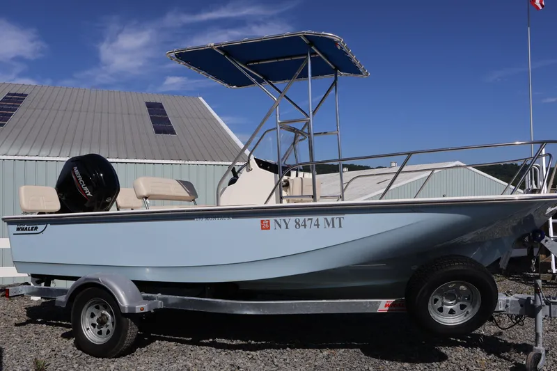 Slide: The Image of 2023 Boston Whaler 170 Montauk boat on trailer, parked outdoors under clear sky. - 4
