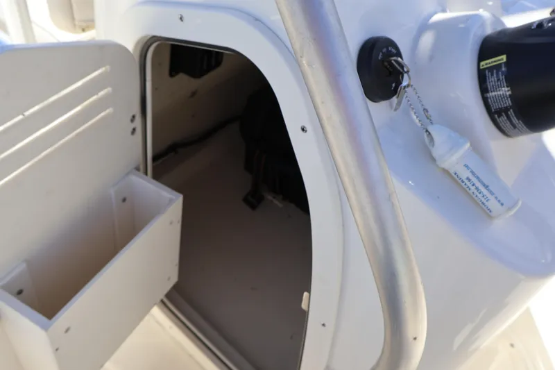 Slide: The Image of 2023 Boston Whaler 170 Montauk console storage with open compartment and key ignition. - 40
