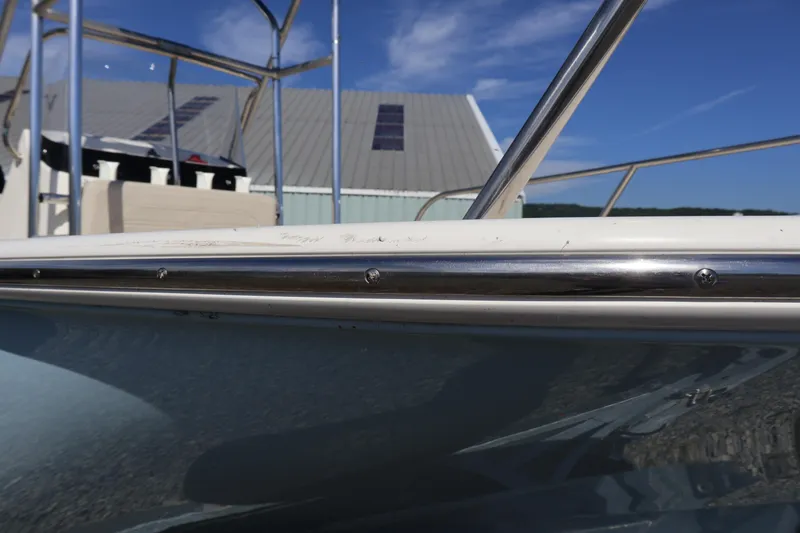 Slide: The Image of 2023 Boston Whaler 170 Montauk boat detail with stainless steel railing under blue sky. - 5