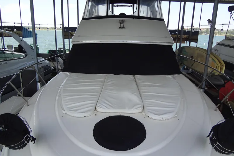 Slide: The Image of 2005 Silverton 34 Convertible yacht docked, featuring a covered bow area. - 12
