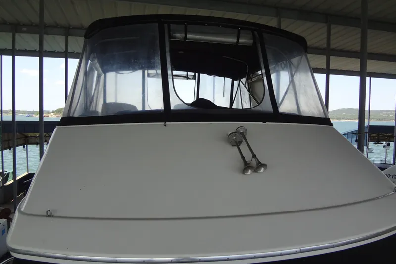 Slide: The Image of 2005 Silverton 34 Convertible boat docked under a covered marina. - 13