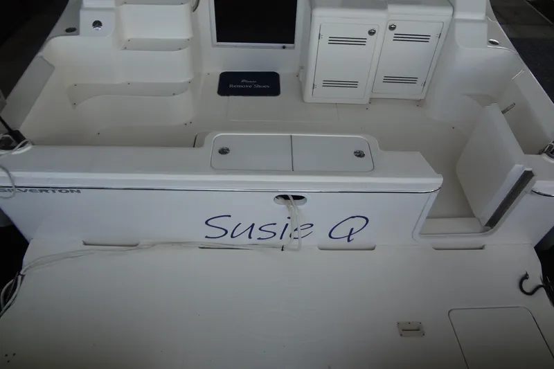 Slide: The Image of 2005 Silverton 34 Convertible boat deck with "Susie Q" name, white seating, and storage compartments. - 15