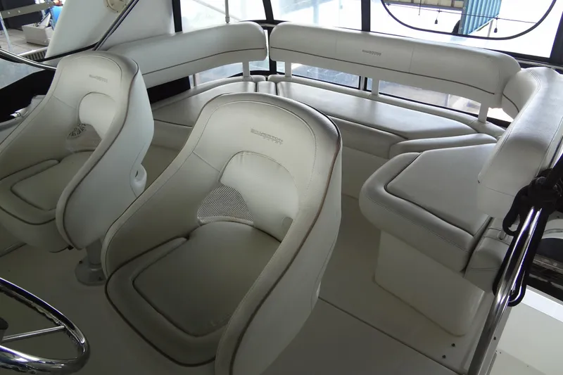 Slide: The Image of Interior seating of 2005 Silverton 34 Convertible yacht, featuring white cushioned seats. - 27