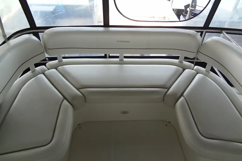 Slide: The Image of Interior seating of a 2005 Silverton 34 Convertible yacht, featuring white cushioned benches. - 30