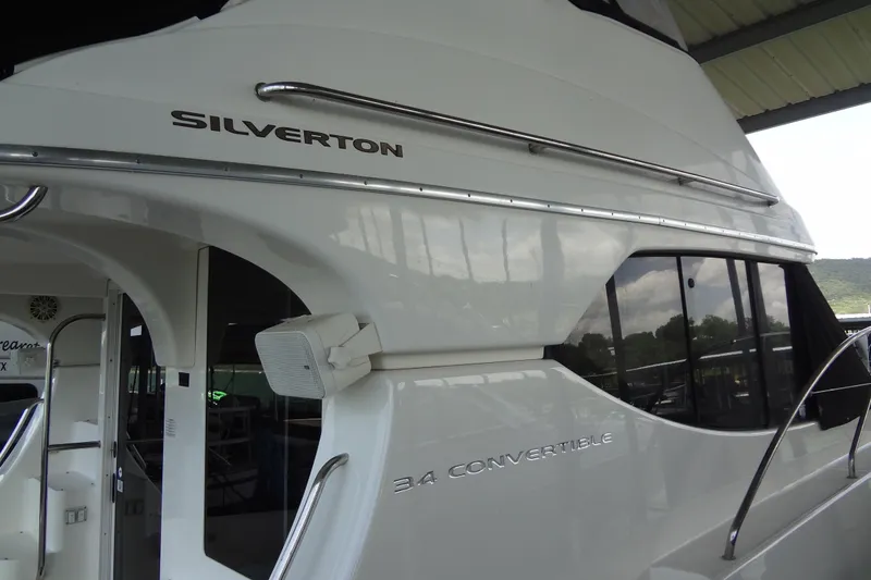 Slide: The Image of 2005 Silverton 34 Convertible yacht, sleek white exterior with large windows. - 4