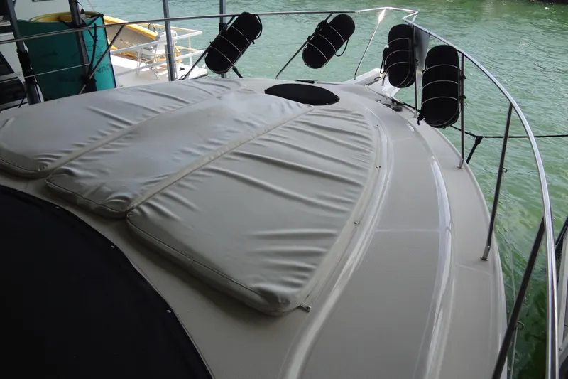 Slide: The Image of 2005 Silverton 34 Convertible yacht with cushioned deck, docked on calm water. - 8