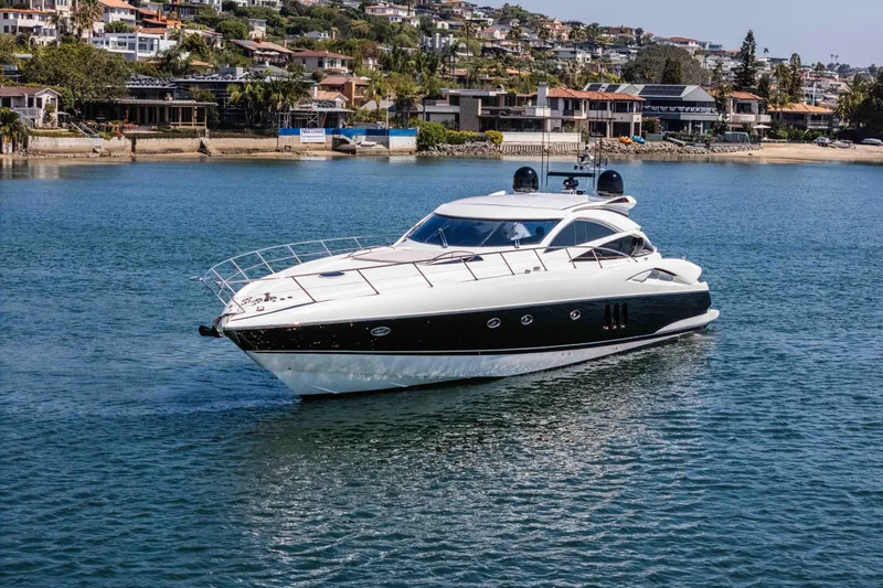 Slide: The Image of 2005 Sunseeker Predator 68 yacht cruising near coastal homes. - 5