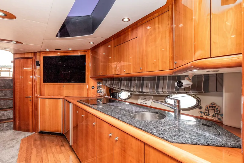Slide: The Image of Luxurious 2005 Sunseeker Predator 68 yacht interior with sleek wood cabinetry and modern amenities. - 10