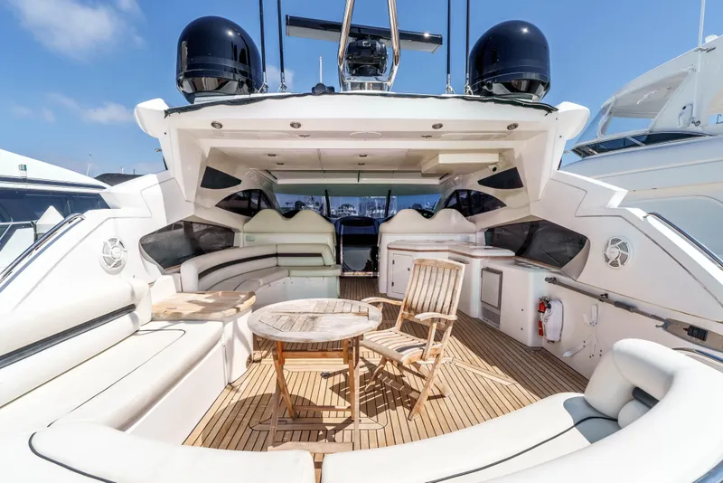 Slide: The Image of Luxurious 2005 Sunseeker Predator 68 yacht deck with seating and table, under clear skies. - 2