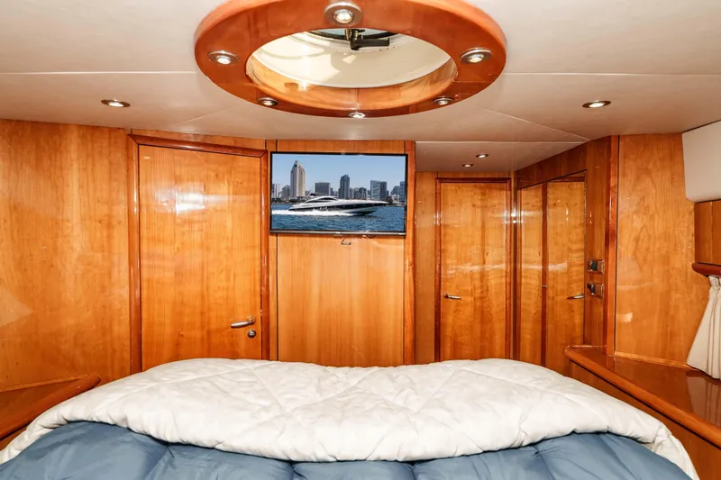 Slide: The Image of Luxurious 2005 Sunseeker Predator 68 yacht cabin with wood paneling and cozy bedding. - 31