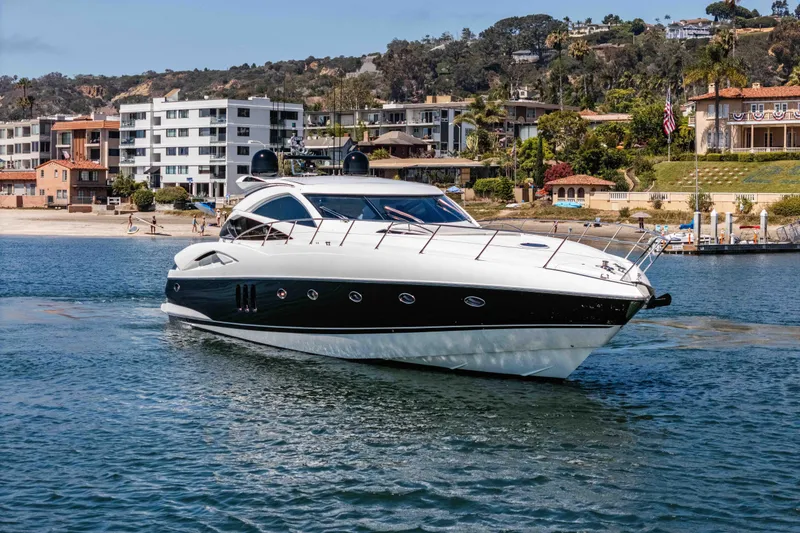 Slide: The Image of 2005 Sunseeker Predator 68 yacht cruising near coastal residences. - 3