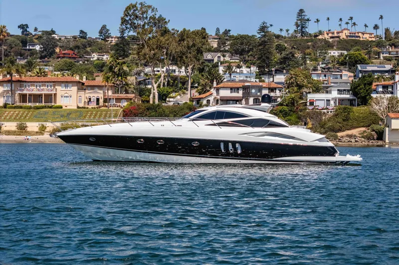 Slide: The Image of 2005 Sunseeker Predator 68 yacht cruising near coastal homes. - 6