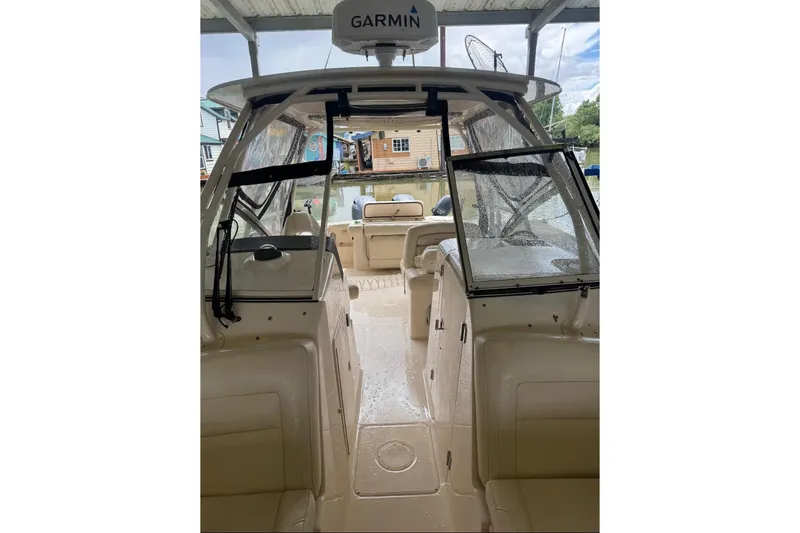 Slide: The Image of 2020 Grady White 275 Freedom boat interior with Garmin equipment, docked under shelter. - 13