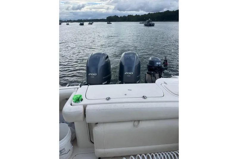 Slide: The Image of 2020 Grady White 275 Freedom boat with twin 200 horsepower engines on a calm lake. - 17