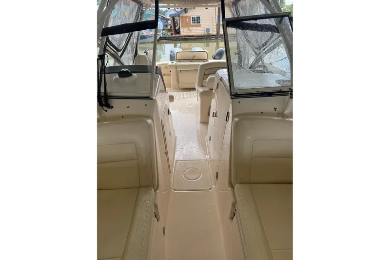 Slide: The Image of 2020 Grady White 275 Freedom boat interior with beige seating and clear canopy. - 19