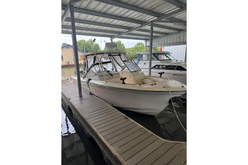 Slide: The Image of 2020 Grady White 275 Freedom boat docked under a covered marina. - 2