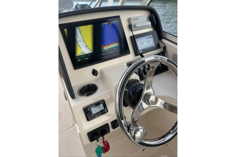Slide: The Image of Helm of 2020 Grady White 275 Freedom boat with navigation screens and steering wheel. - 20