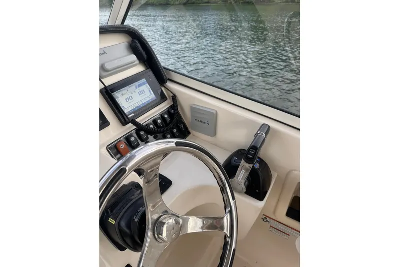 Slide: The Image of 2020 Grady White 275 Freedom boat helm with Garmin display and steering wheel. - 21