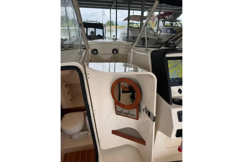 Slide: The Image of 2020 Grady White 275 Freedom boat interior with helm, seating, and cabin view. - 8