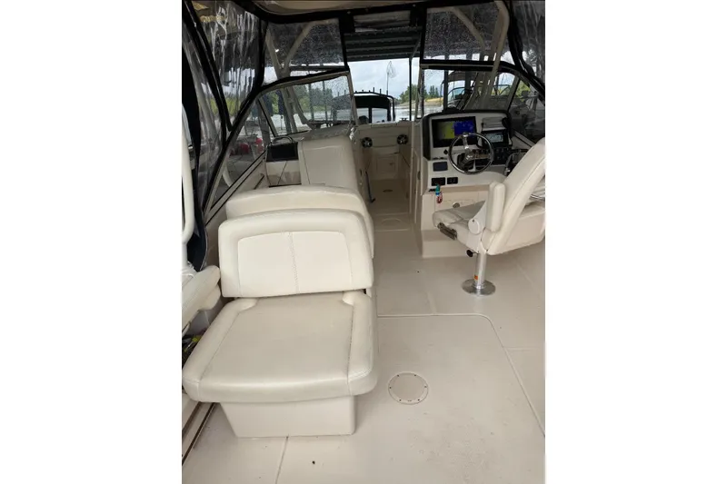 Slide: The Image of Interior of a 2020 Grady White 275 Freedom boat with beige seating and helm controls. - 9