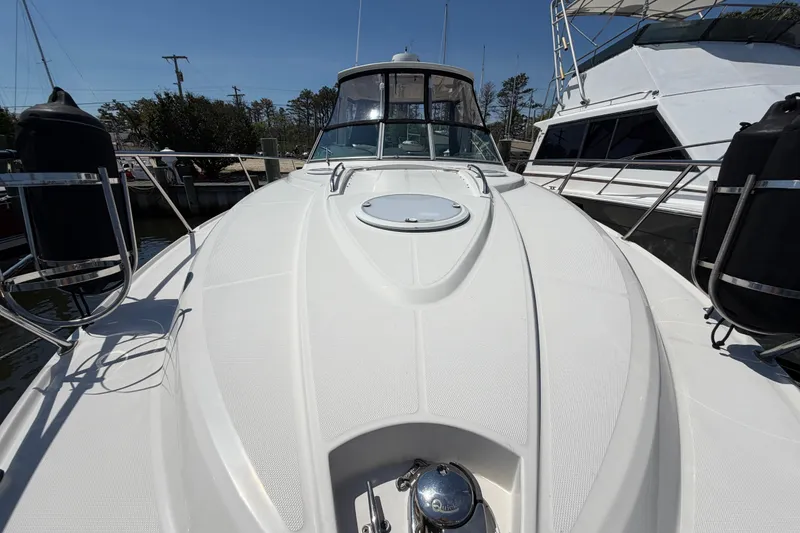 Slide: The Image of 2009 Monterey 340 Sport Yacht, sleek white deck, docked at marina under clear blue sky. - 45