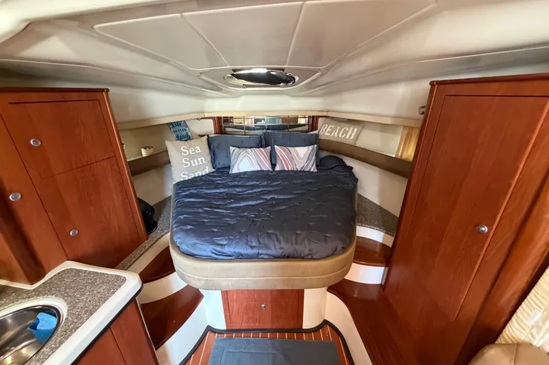 Slide: The Image of Luxurious cabin interior of a 2009 Monterey 340 Sport Yacht with cozy bedding and wooden cabinetry. - 31