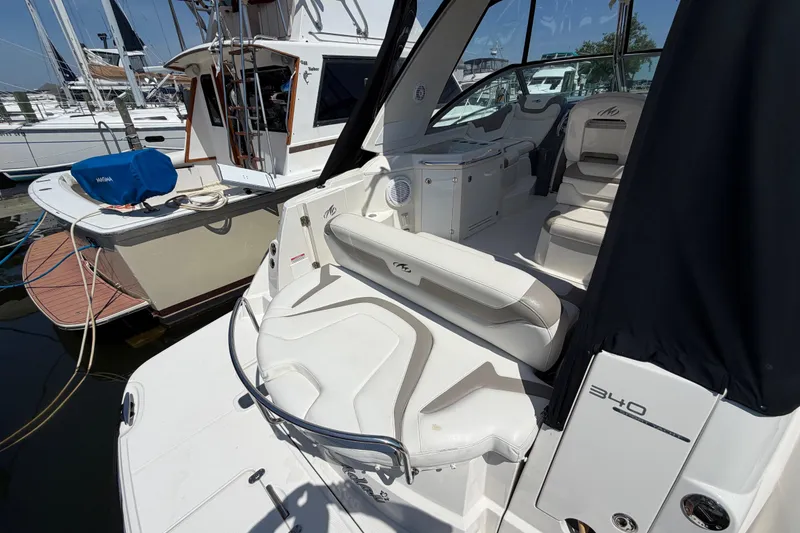 Slide: The Image of 2009 Monterey 340 Sport Yacht interior with white seating at marina. - 13