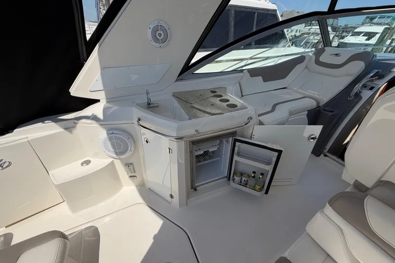 Slide: The Image of Interior of 2009 Monterey 340 Sport Yacht with seating, mini fridge, and sink. - 21