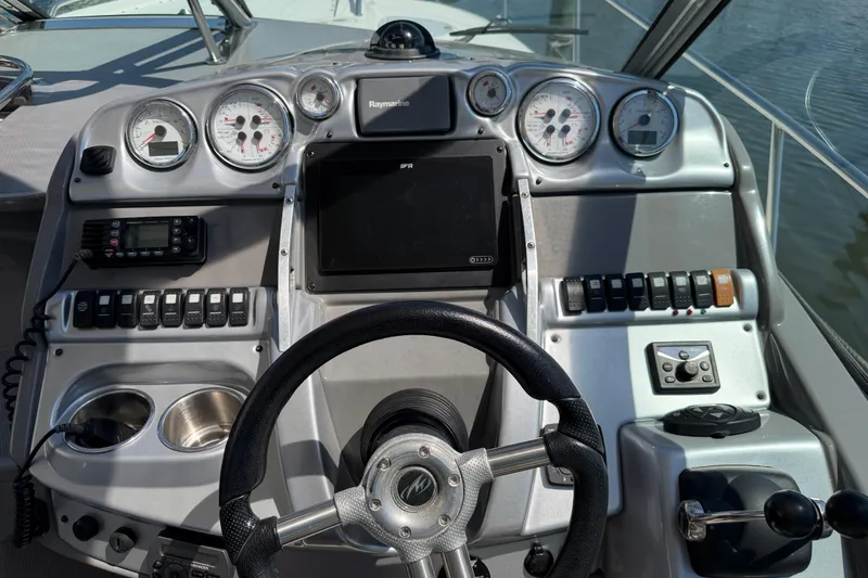 Slide: The Image of Dashboard of a 2009 Monterey 340 Sport Yacht with steering wheel and navigation controls. - 25