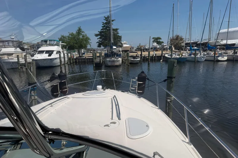 Slide: The Image of 2009 Monterey 340 Sport Yacht docked in a marina with sailboats and clear skies. - 26