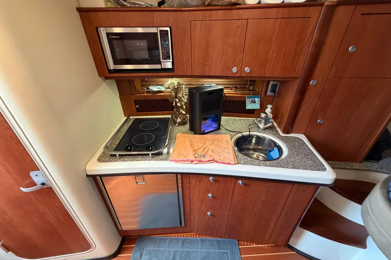 Slide: The Image of 2009 Monterey 340 Sport Yacht kitchen with stove, sink, and microwave. - 30