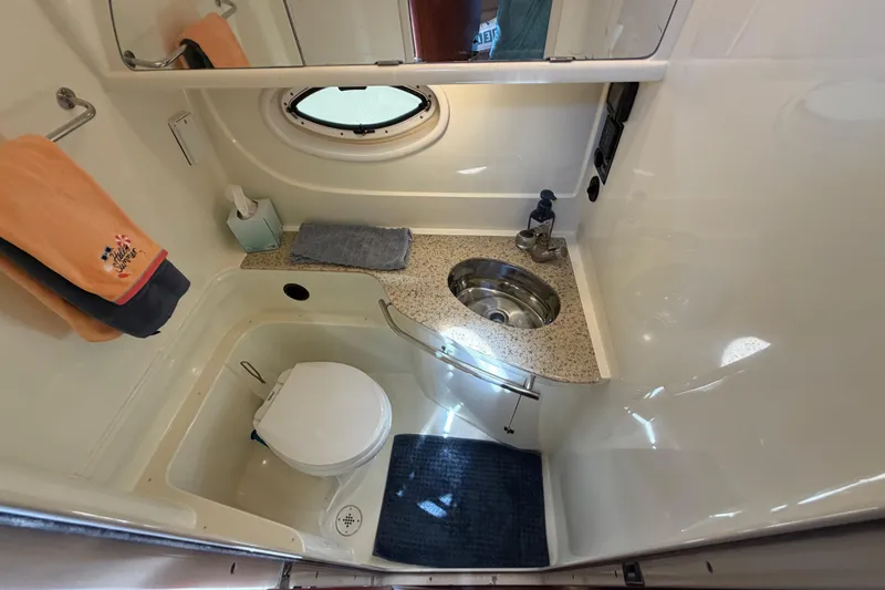 Slide: The Image of 2009 Monterey 340 Sport Yacht bathroom with sink, toilet, and porthole window. - 34
