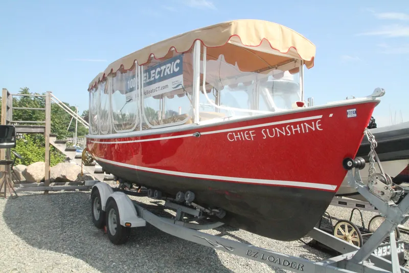 The Image of 2004 Duffy 21 Classic electric boat "Chief Sunshine" on trailer, vibrant red with canopy. - 1