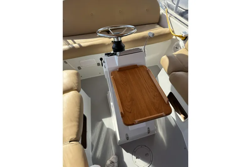 Slide: The Image of Interior of a 2004 Duffy 21 Classic boat with beige seating and wooden table. - 10