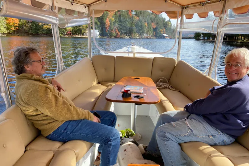Slide: The Image of Two people relaxing on a 2004 Duffy 21 Classic boat on a scenic lake. - 11