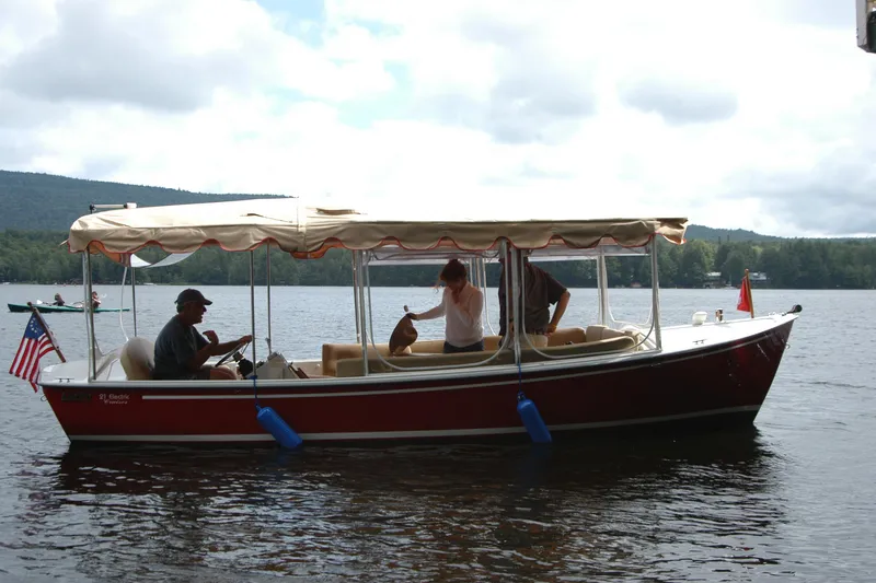 Slide: The Image of 2004 Duffy 21 Classic boat on a lake with passengers under a canopy. - 14
