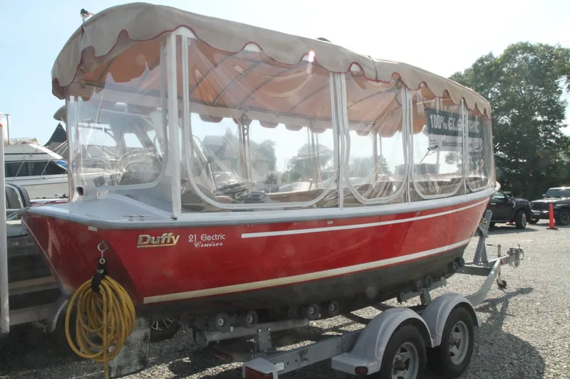 Slide: The Image of Red 2004 Duffy 21 Classic electric boat on trailer, parked outdoors. - 3