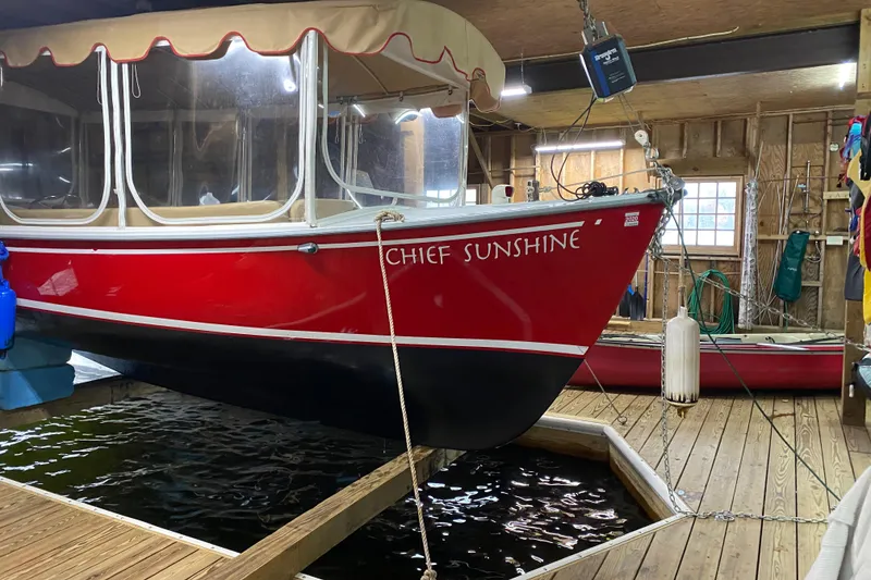 Slide: The Image of Red 2004 Duffy 21 Classic boat named "Chief Sunshine" docked indoors. - 4