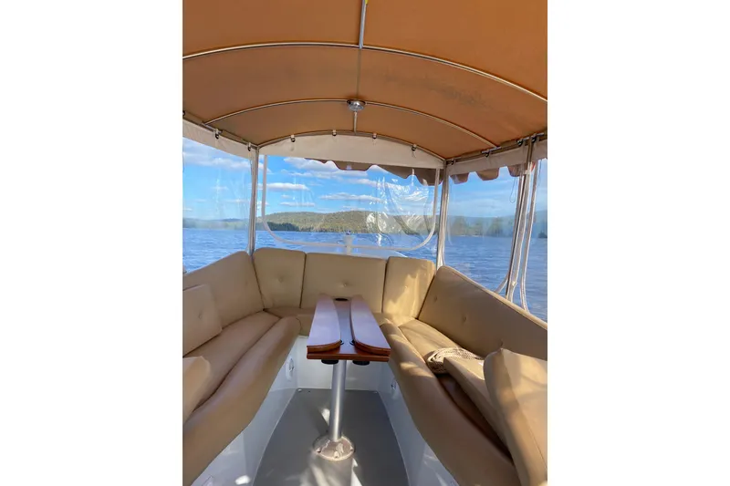 Slide: The Image of Interior view of a 2004 Duffy 21 Classic boat with beige seating and scenic water backdrop. - 5