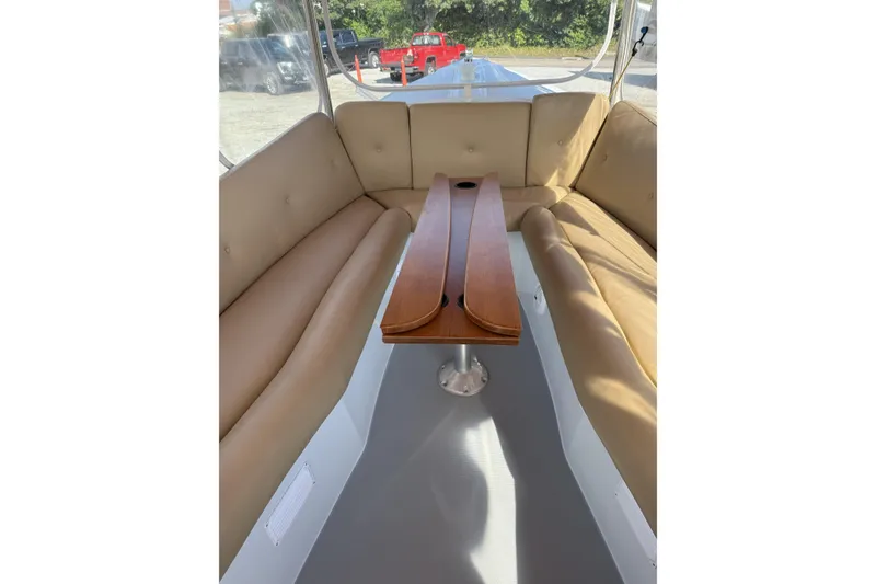 Slide: The Image of Interior of a 2004 Duffy 21 Classic boat with tan seating and wooden table. - 7