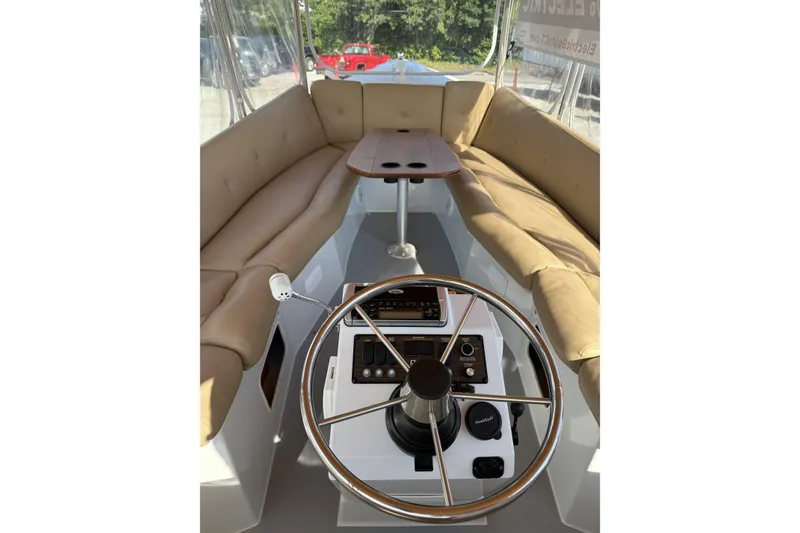 Slide: The Image of Interior of a 2004 Duffy 21 Classic boat with tan seating and steering wheel. - 8
