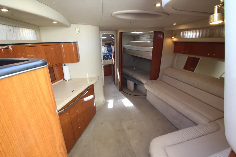 Slide: The Image of Interior of 2000 Sea Ray 410 Express Cruiser with elegant wood cabinetry and plush seating. - 14