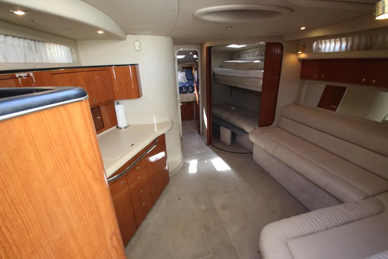 Slide: The Image of Interior of 2000 Sea Ray 410 Express Cruiser with wood cabinetry and beige seating. - 15