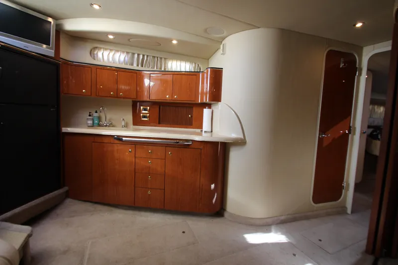 Slide: The Image of Interior of 2000 Sea Ray 410 Express Cruiser with wooden cabinetry and modern amenities. - 17