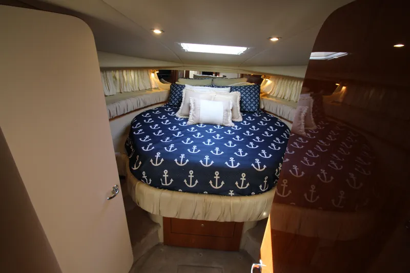 Slide: The Image of Luxurious cabin interior of 2000 Sea Ray 410 Express Cruiser with anchor-themed bedding. - 25
