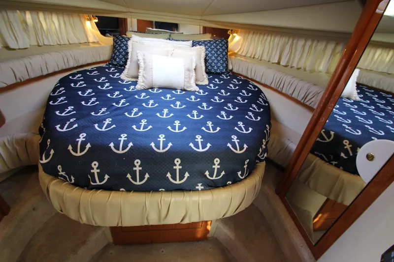 Slide: The Image of Luxurious cabin interior of 2000 Sea Ray 410 Express Cruiser with nautical-themed bedding. - 26