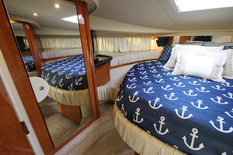 Slide: The Image of Luxurious cabin interior of 2000 Sea Ray 410 Express Cruiser with nautical-themed bedding. - 27
