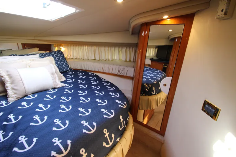 Slide: The Image of Luxurious cabin interior of 2000 Sea Ray 410 Express Cruiser with nautical-themed bedding. - 28